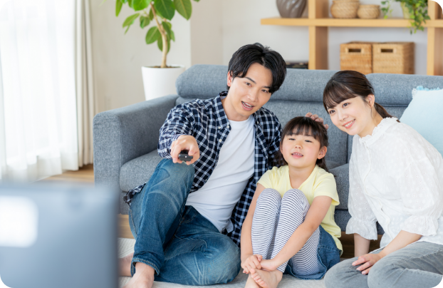 テレビをみる若い夫婦と１人の子供